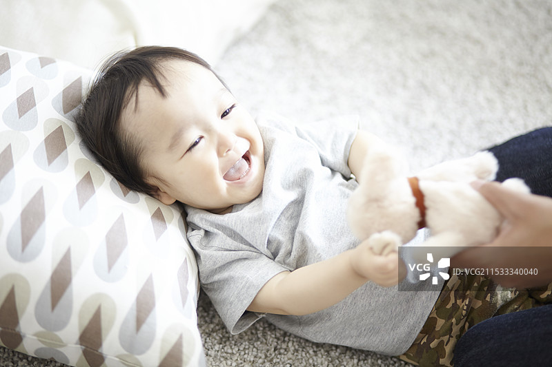 孩子在玩洋娃娃后微笑。图片素材