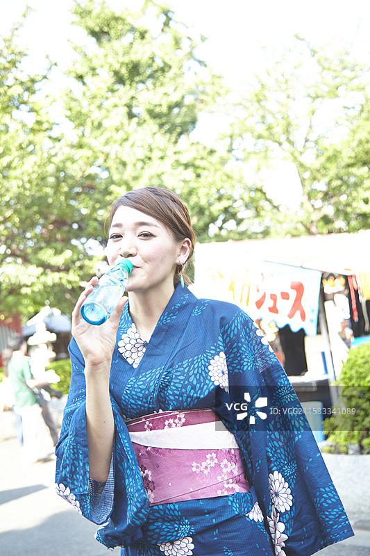 穿着和服的女人在喝苹果酒图片素材