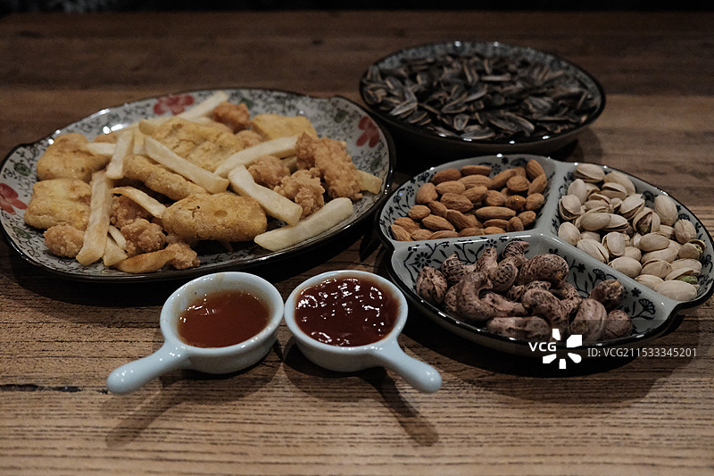 中国休闲娱乐健康生活方式拍摄主题，一堆薯条鸡米花炸鸡瓜子腰果巴旦木开心果食物特写，室内无人图像摄影图片素材