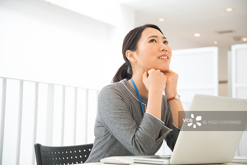 在笔记本电脑前的女人，颧骨突出图片素材