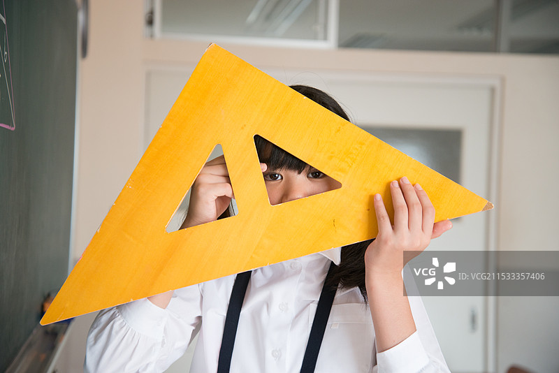 小学女孩在黑板前拿着三角尺图片素材