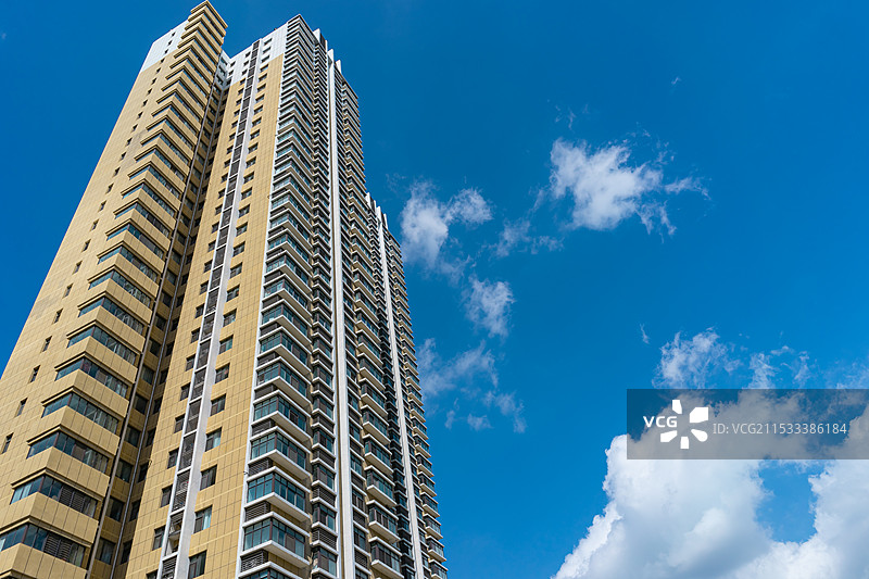 中国房地产拍摄主题，低视角仰拍居住区高层楼房和天空中的蓝天和云景，户外白昼无人图像摄影图片素材