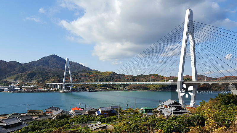日本广岛县尾道市，岛波海道因岛段，濑户内海海岛上的农家和生口桥图片素材