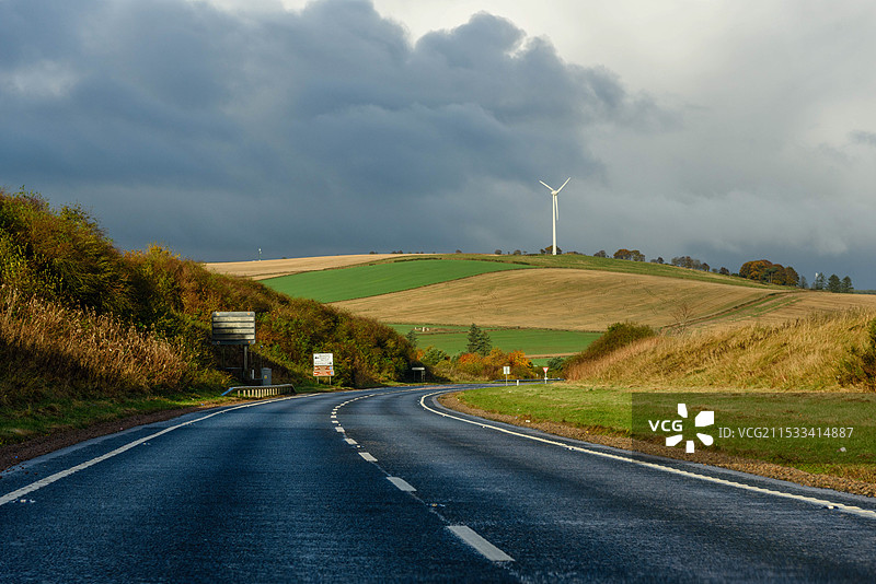 英国苏格兰田野中向远处延伸的弯曲公路图片素材