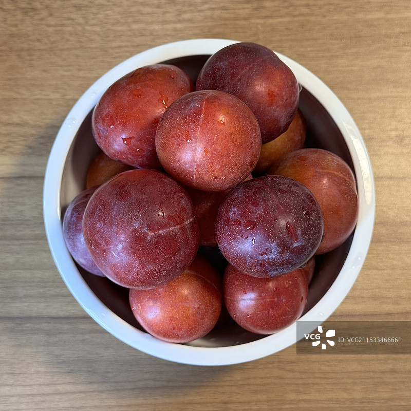 就在桌子上碗里的水果的正上方图片素材