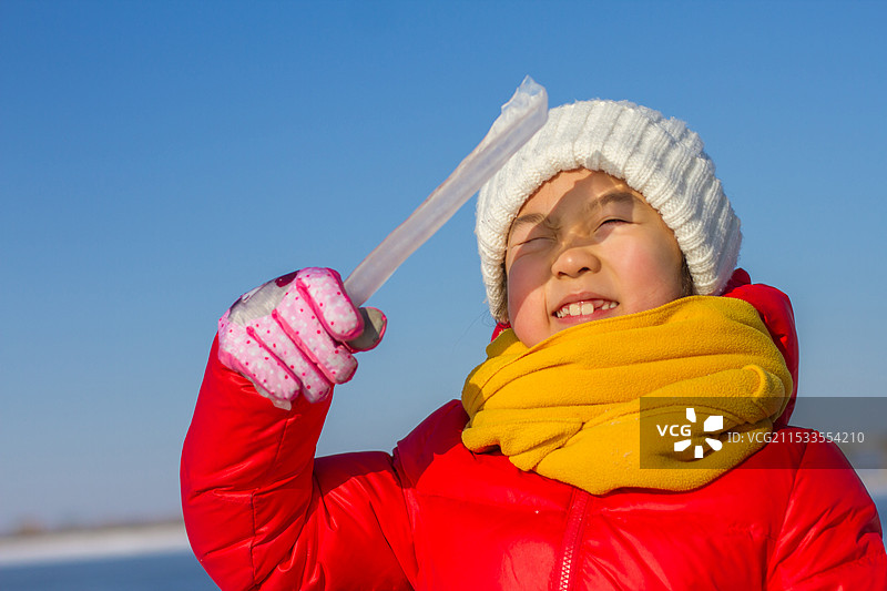 晴朗的冬日里玩雪的红衣小女孩图片素材