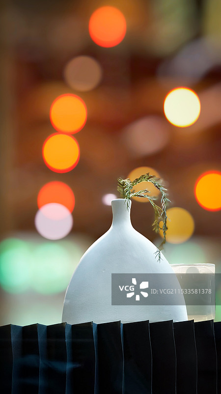 "静谧之夜：白色花瓶与彩色光斑的交响曲"图片素材