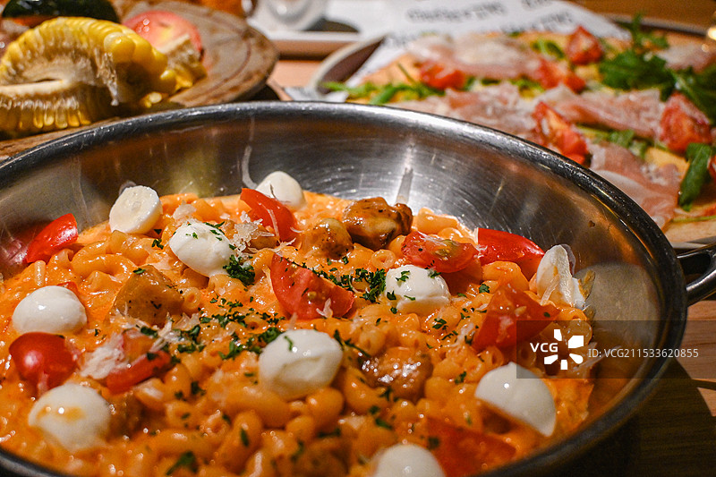 餐桌上盘子里的意面特写镜头（马苏里拉鸡肉螺旋意面）图片素材