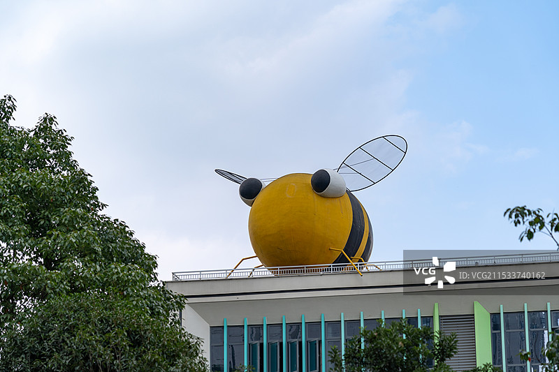 现代建筑楼顶上的一只蜜蜂造型雕塑图片素材