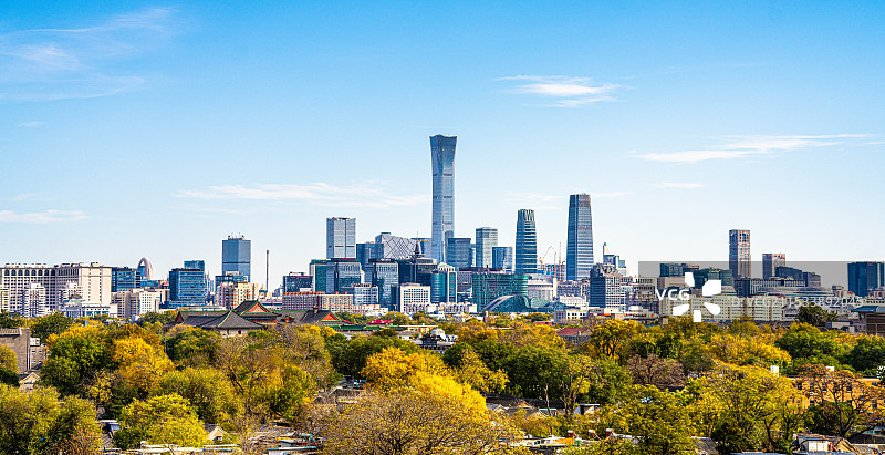 秋日鼓楼上眺望，北京传统胡同与远处现代CBD天际线在蓝天白云下形成鲜明对比，展现古今结合的城市风貌。图片素材