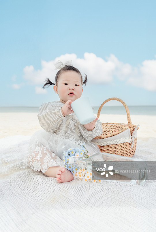 海湾沙滩上的快乐可爱的女婴图片素材