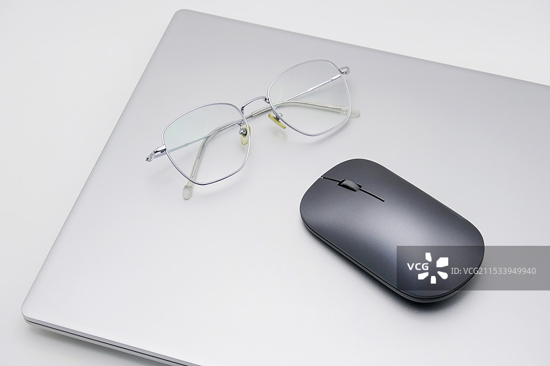 笔记本上放着鼠标和眼镜，显得商务，沟通，科技图片素材