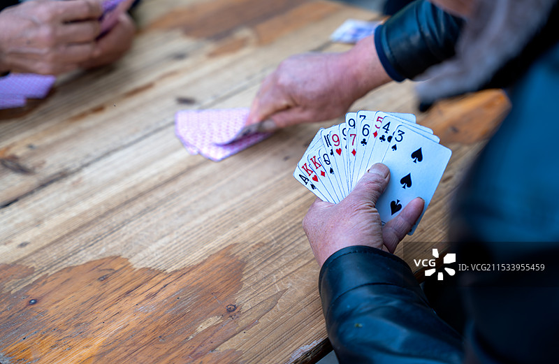 一群退休老年人在一起打掼蛋的特写图片素材