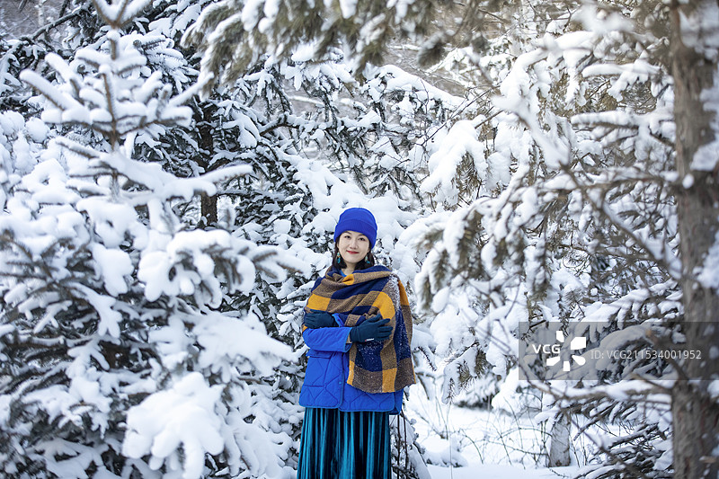 穿着暖和衣服的美人站在雪地上图片素材