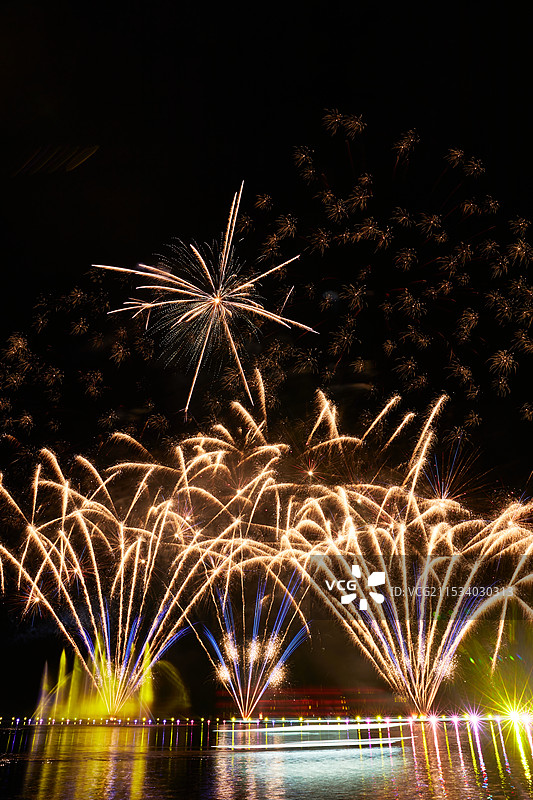 旅游景区湖面绽放的绚丽烟花礼花竖图图片素材