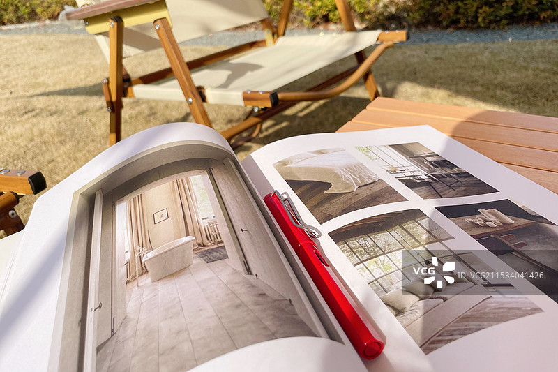 翻开的杂志和红色钢笔图片素材