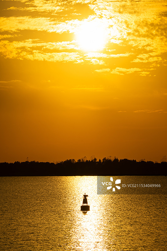上海淀山湖灿烂夕阳下的湖面反光和浮标图片素材