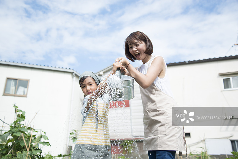 父母和孩子用喷壶洒水图片素材