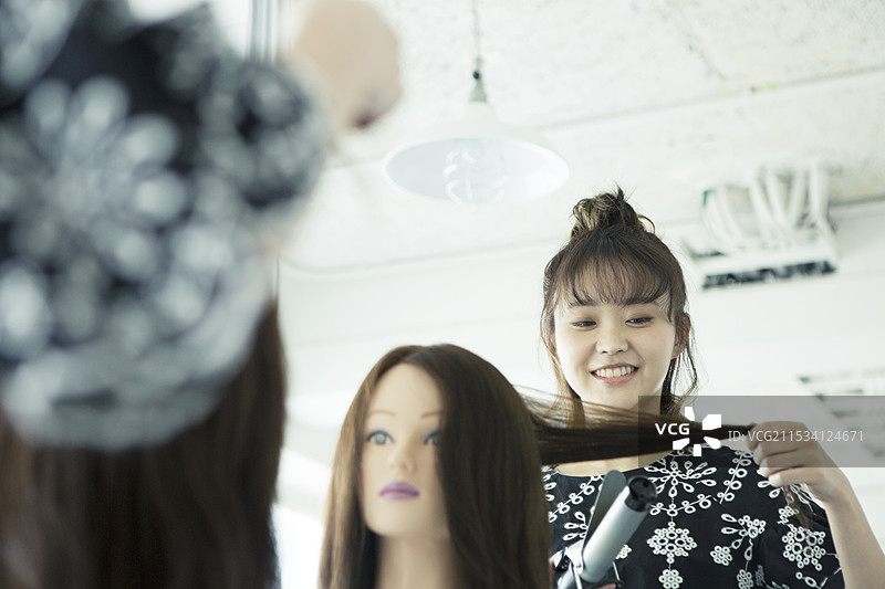 女性发型师在假发上造型图片素材