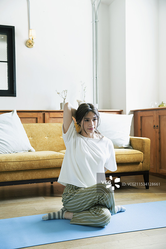 20多岁的女性在房间里做瑜伽姿势图片素材