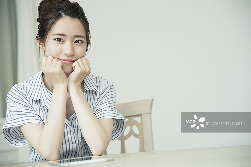 20多岁的女性对着镜头微笑，展现出高高的颧骨。图片素材