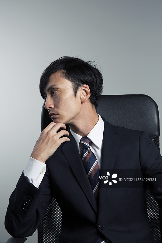 坐在椅子上的男子肖像，颧骨突出图片素材