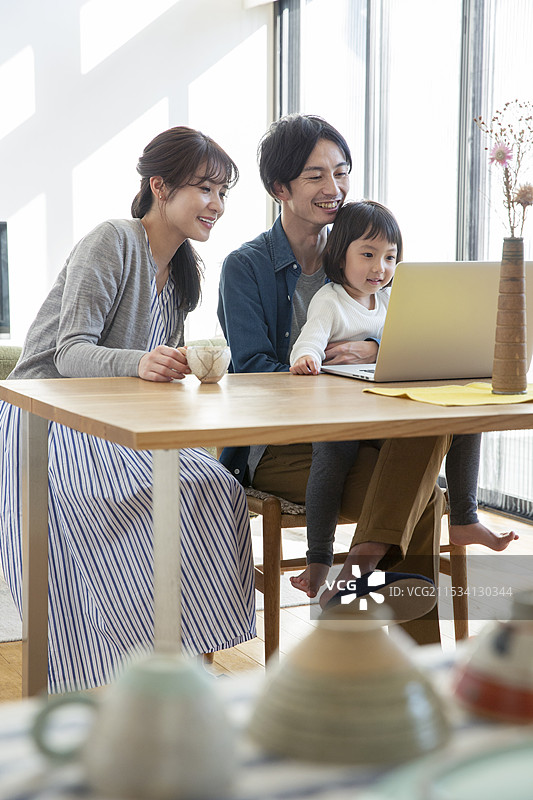 微笑的父母和孩子在看电脑图片素材