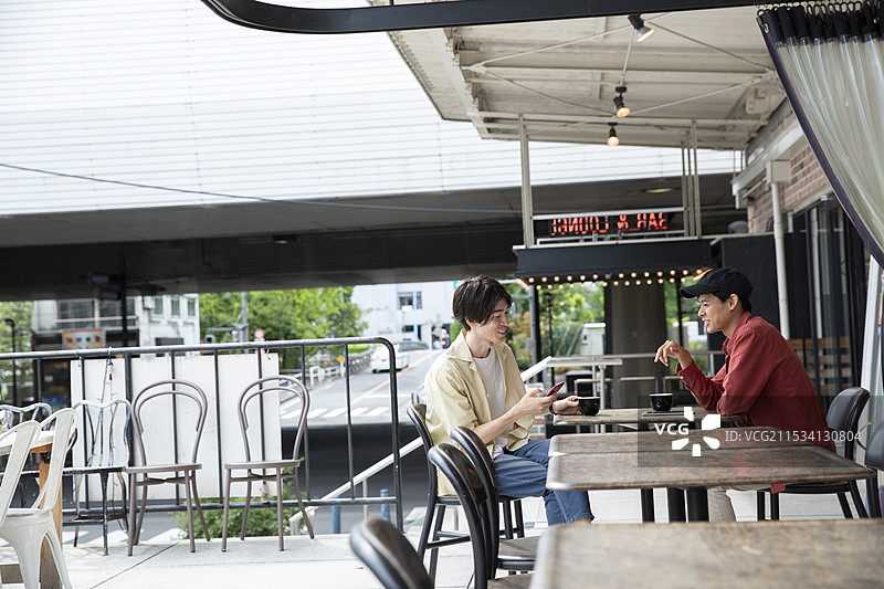 两名20多岁的男子在咖啡馆交谈图片素材