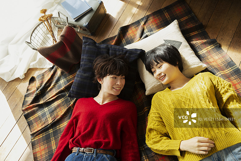 两个20多岁的女性躺在房间里图片素材