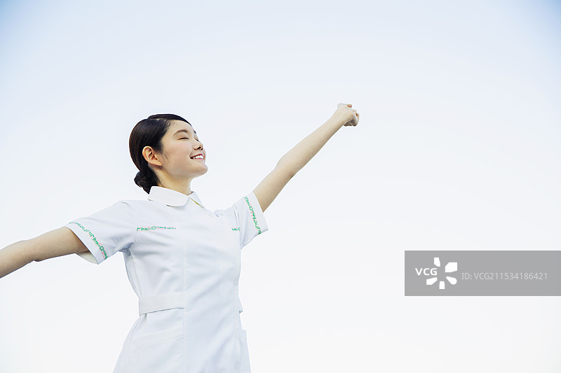 20多岁的女性医疗工作者在户外祈祷。图片素材