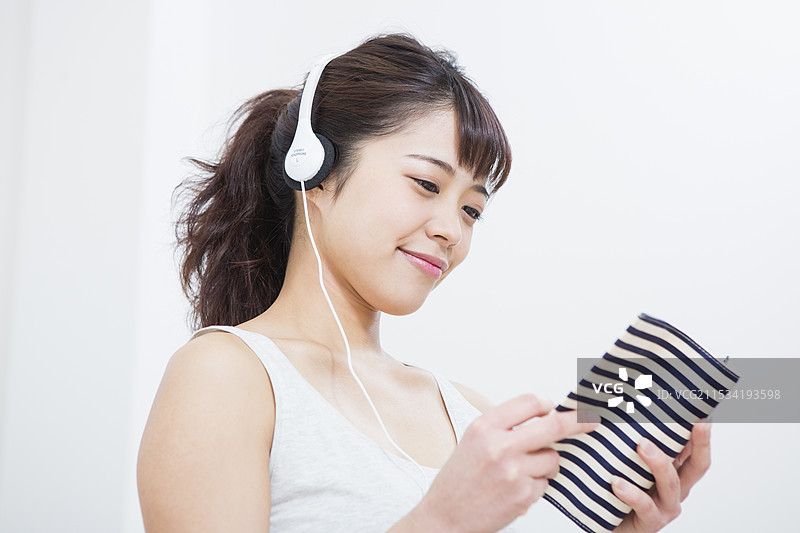 女人一边听音乐一边阅读一本书图片素材