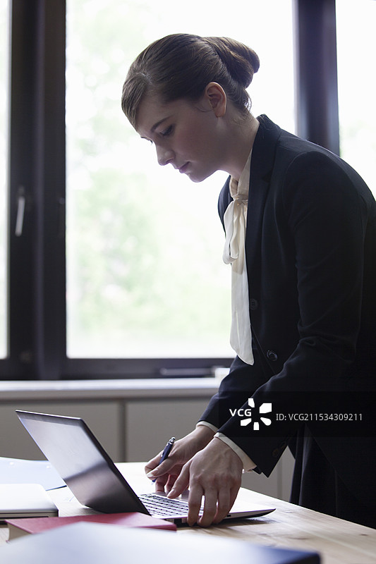 商务人士站着使用电脑图片素材