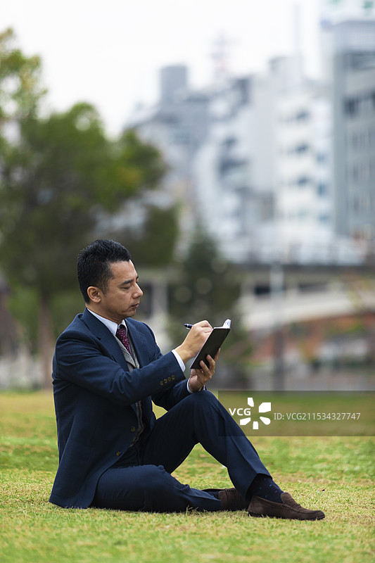商人正在他的笔记本上写字图片素材