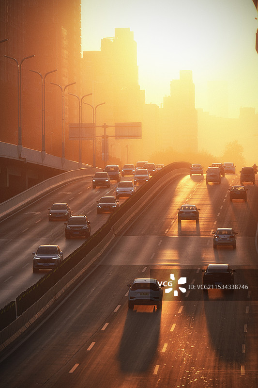 夕阳下的城市绕城高速车流图片素材
