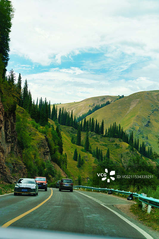 独库公路上的绿色植被与蓝天白云图片素材