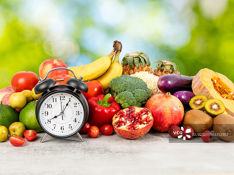 丰富多种的新鲜蔬菜水果和一个闹钟图片素材