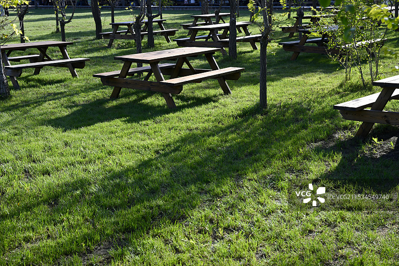 中国天津市宁河区七里海镇“七星岛湿地风景区”公园里草地上的空椅子和桌子图片素材