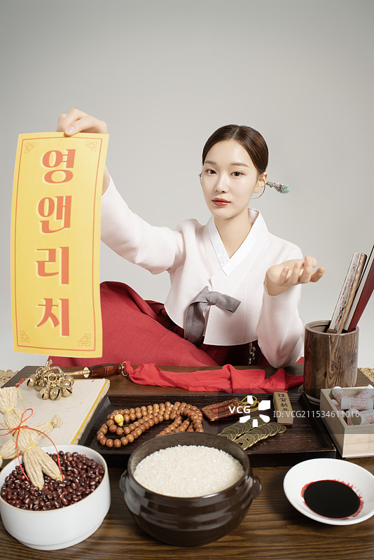 一位穿着韩服并握着护身符的萨满坐着图片素材