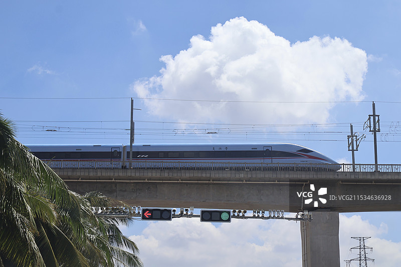 海南海口蓝天白云下的高铁铁轨复兴号列车划过高铁铁轨图片素材