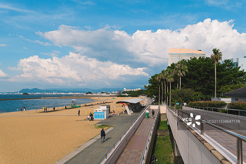 晴朗天空下的日本九州福冈百道滨海滨公园海滩上的人们与道路图片素材