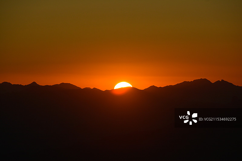 橘色天空衬托山峦的剪影景色图片素材