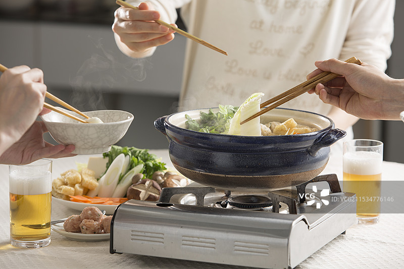 围坐在相扑火锅旁一起用餐图片素材