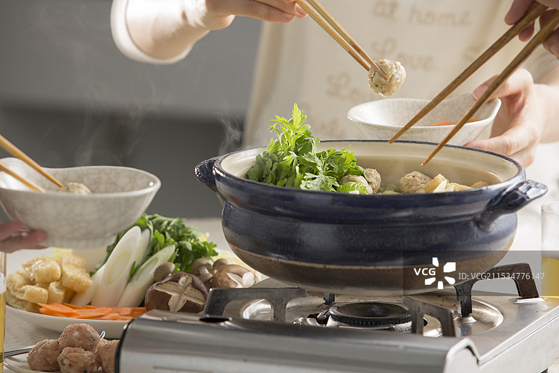 围坐在相扑火锅旁一起用餐图片素材