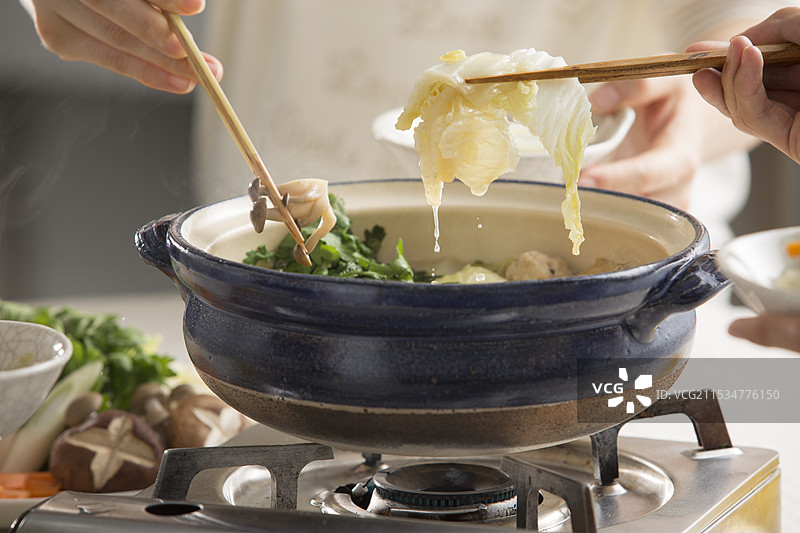 围坐在相扑火锅旁一起用餐图片素材