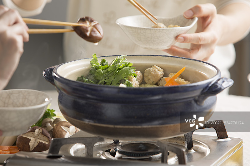 围坐在相扑火锅旁一起用餐图片素材