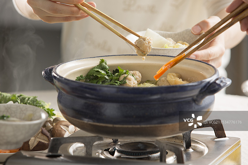 围坐在相扑火锅旁一起用餐图片素材