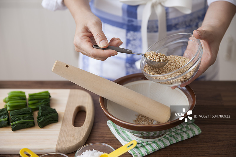 女人在研钵中放入芝麻种子图片素材