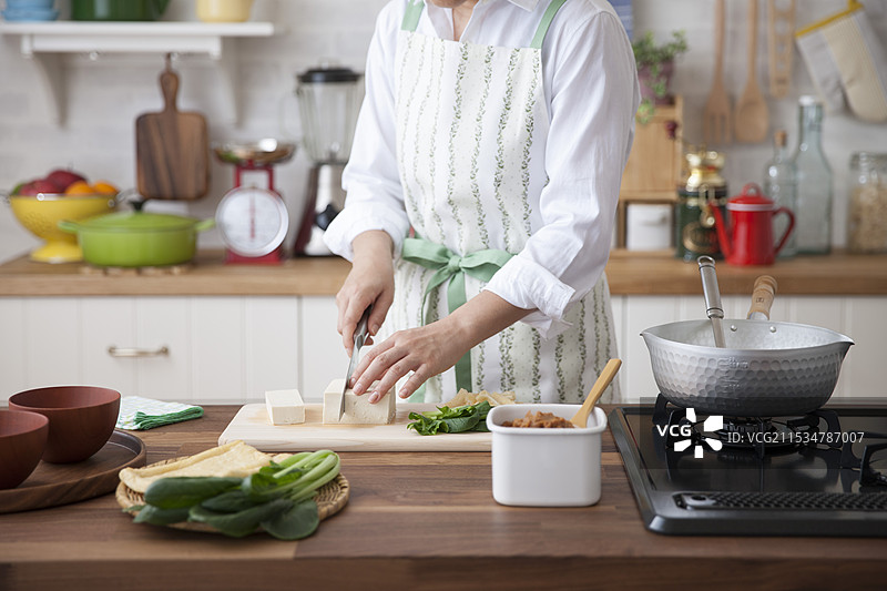 女人用刀切豆腐准备味噌汤图片素材
