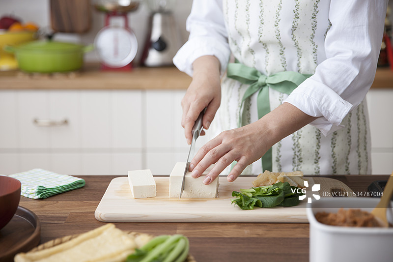女人用刀切豆腐准备味噌汤图片素材