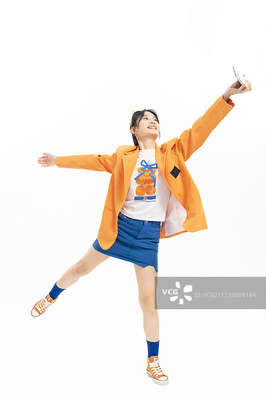 手拿手机跳跃的时尚女孩图片素材